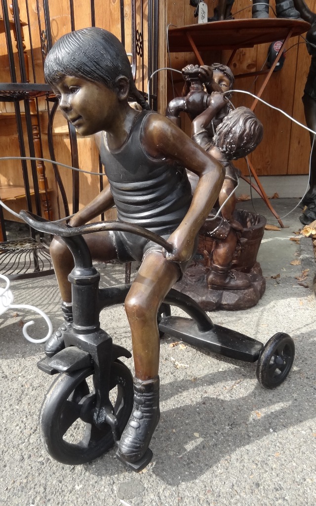 Bronzefigur Mädchen auf Dreirad